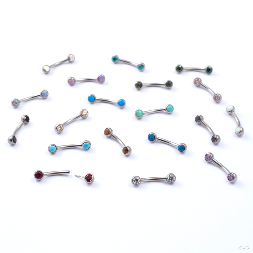 Curved press-fit posts featuring gemstones for navel piercings