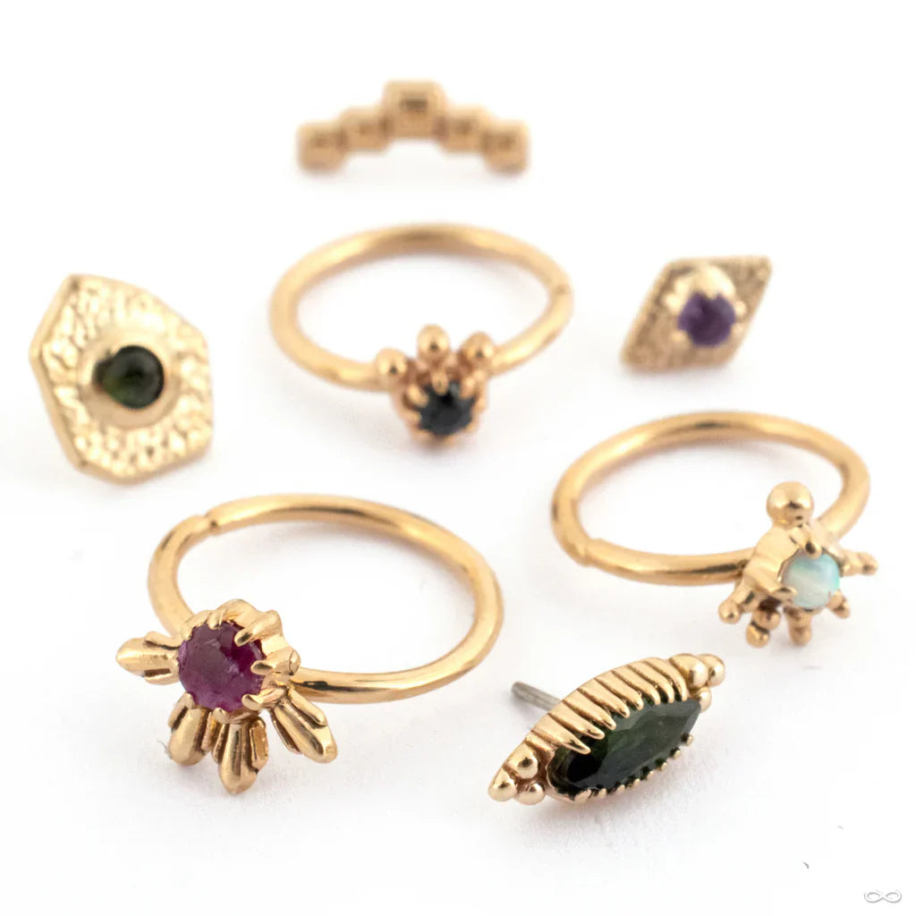 Gold rings and body jewelry collection from Sacred Symbols at Infinite Body Piercing