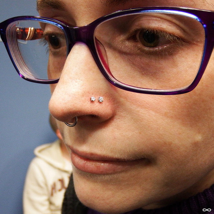 Two nostril piercings with Prong-set Gemstone Press-fit End in Titanium from NeoMetal in 2mm & 2.5mm Clear CZ