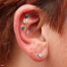 Three outer helix piercings with Prong-set Gemstone Press-fit End in Titanium from NeoMetal in 4mm Clear CZ & Emerald