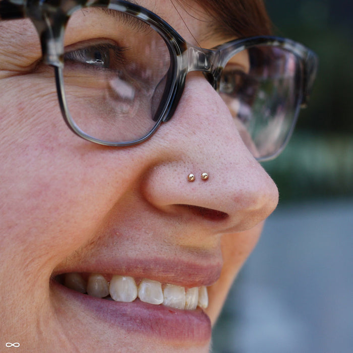 Two nostril piercings with Ball Press-fit End in Gold from LeRoi in 2mm